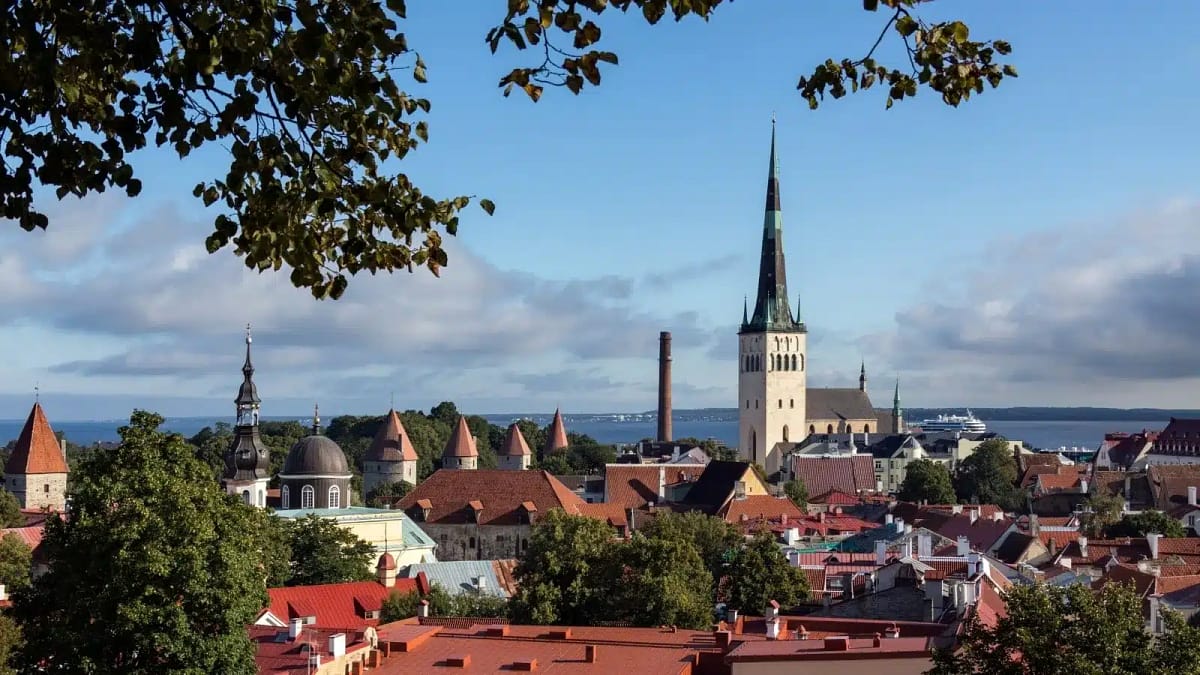 A church steeple rises above traditional houses in Tallinn, Estonia