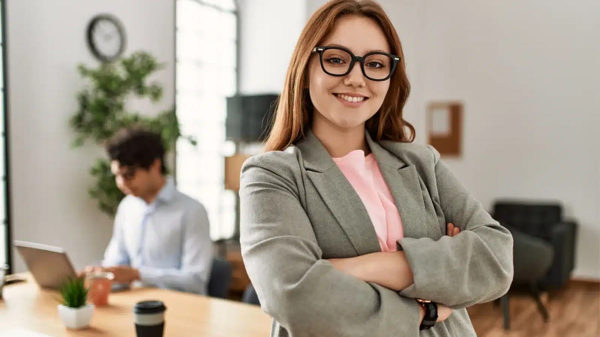 A woman wearing glasses and crossing her arms.