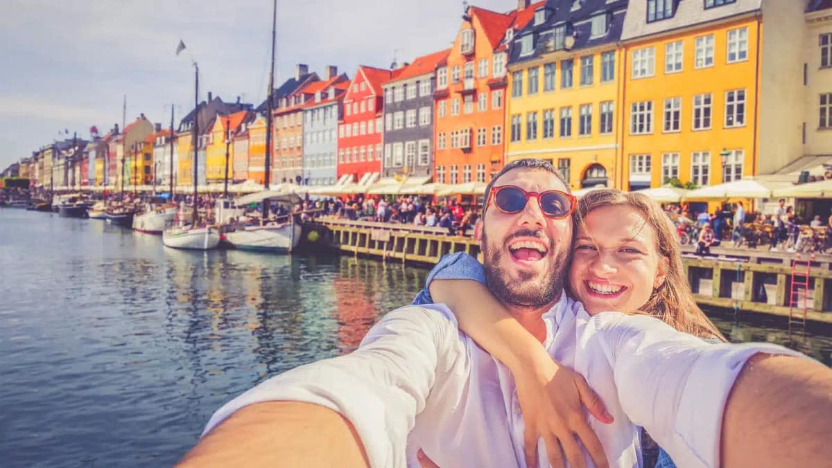 Couple takes a selfie in the Nyhavn district of Copenhagen, Denmark
