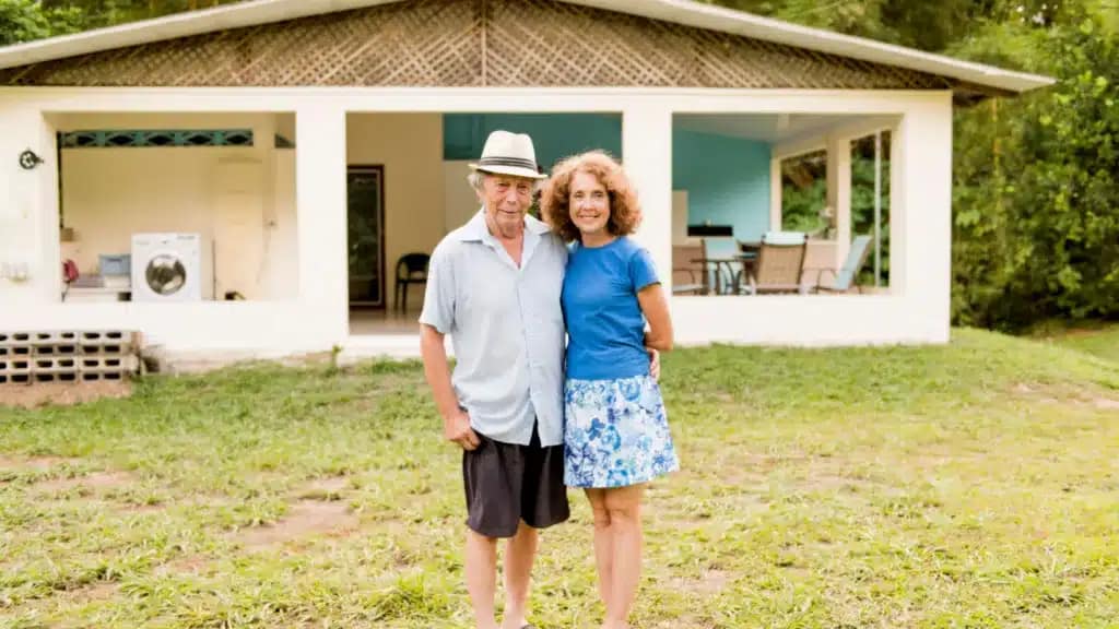 Senior couple hugs outside their house in Costa Rica
